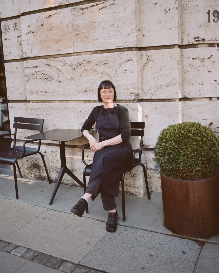 Møntergade’s ‘lunch captain’, Thia, sitting on a chair outside the restaurant