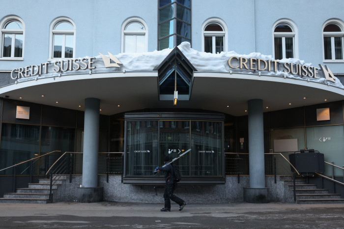 A skier walks past the Credit Suisse building 