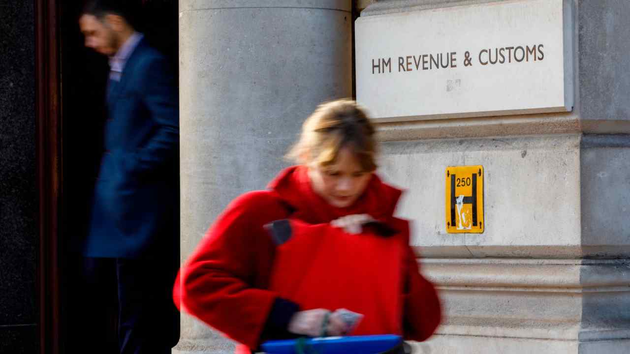 A woman walks past HM Revenue & Customs office on Whitehall, London