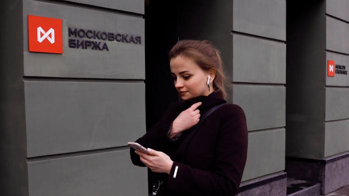 A woman passes the entrance of the Russian stock exchange in Moscow