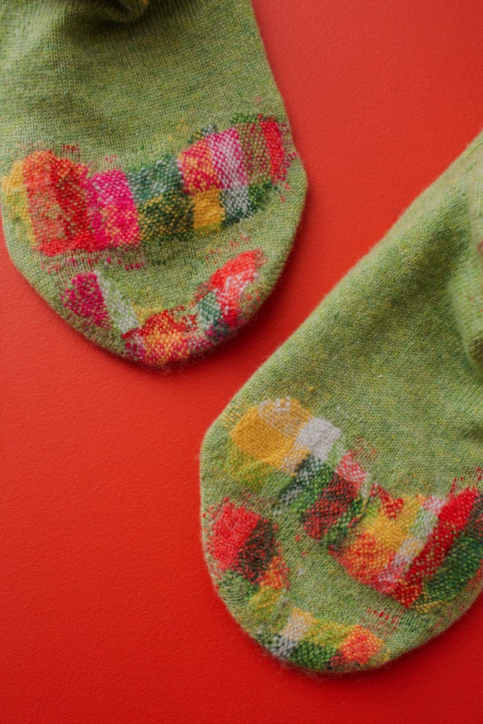 A pair of socks darned with Flora Collingwood-Norris’s “visible mending” technique
