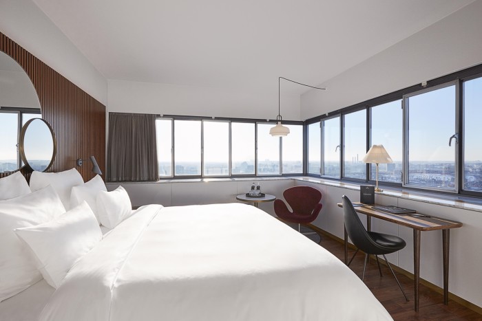 A bed in a room with a panoramic view of Copenhagen at the Radisson Collection Royal Hotel Copenhagen