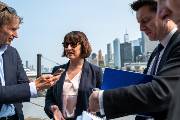 Rachel Reeves being interviewed by journalists against backdrop of New York skyline