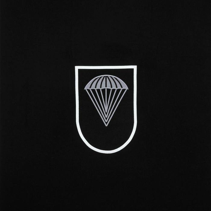 The same emblem now reduced to a parachute in a white line