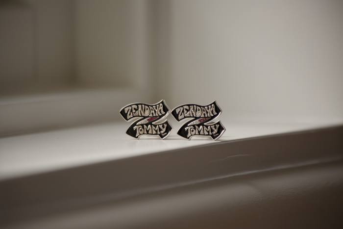 A pair of cuff links with the words “Zendaya/Tommy” engraved on them