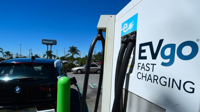 An Electric Vehicle (EV) is plugged in for a charge at EV charging stations in a Walmart parking lot in Duarte, California