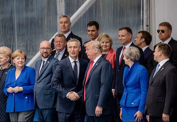 Jens Stoltenberg, secretary general of the North Atlantic Treaty Organization (NATO), center left, and U.S. President Donald Trump, center right, shake hands as world leaders gather for a family photo during the NATO summit