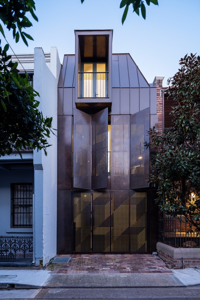 Architect Emma Rees-Raaijmakers of Atelier DAU put perforated bronze screens over the windows of the Chimney House, Sydney, to filter in the light