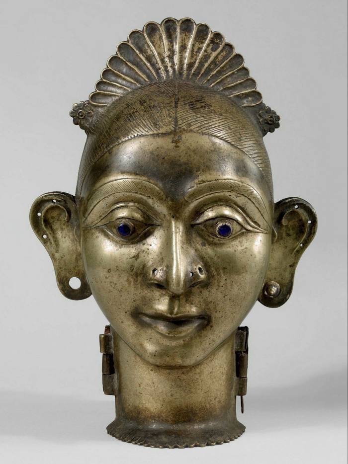 A bronze head of a woman looking curiously