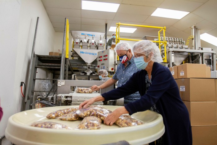 Don and Kim Peacock pack nuts at GNS Foods in Arlington, Texas. Their wholesale business, supplying airlines, evaporated almost overnight when the Covid-19 pandemic started