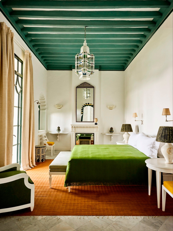 Moroccan-style bedroom with high ceilings and green and blue and orange colours