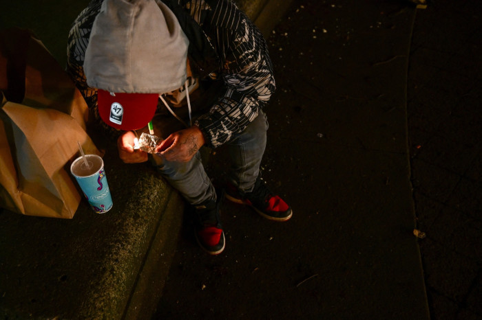  A person is using fentanyl on Park Avenue following the decriminalization of all drugs in downtown Portland, Oregon