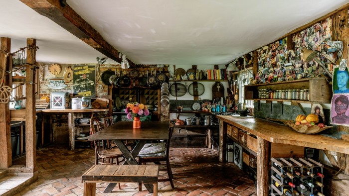A characterful farmhouse kitchen with wood-beamed ceiling, dark wood furniture and tiled floors 