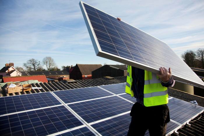 Jake Beautyman installs solar panels on a barn roof on Grange farm, near Balcombe