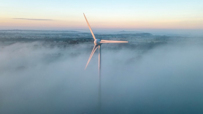 A wind turbine in the early morning mist