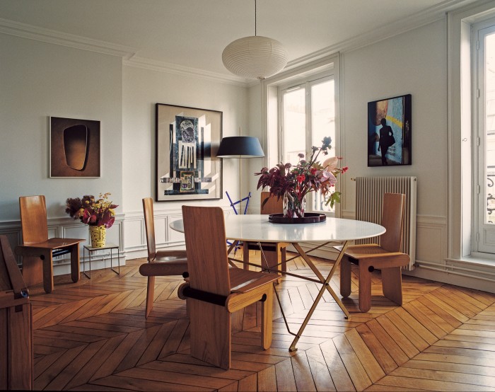 The dining room, with its set of chairs by Tobia Scarpa and 1920s Italian table, above which hangs an Akari lamp. A vintage Italian lamp stands in the far corner; on the walls are (from left) a Geert Goiris photograph, a Ben Sansbury collage and a Nicolas Provost photograph