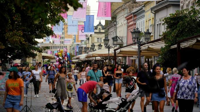Visitors pass bars and restaurants on the pedestrianized Zmaj Jovina Street in Novi Sad, Serbia