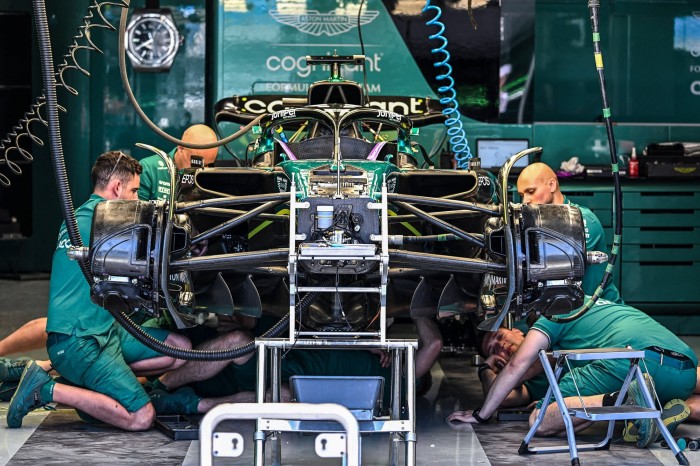 Aston Martin’ technicians work on their car in the pit lane at the Miami International Autodrome