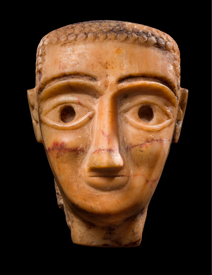 Orangey sculpture of a man with very large eyes