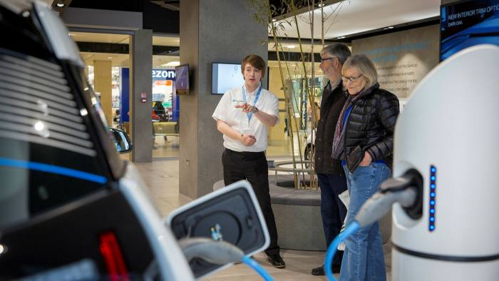 Customers looking around the Electric Vehicle Experience Centre inside a shopping centre on Crown Walk, Milton Keynes