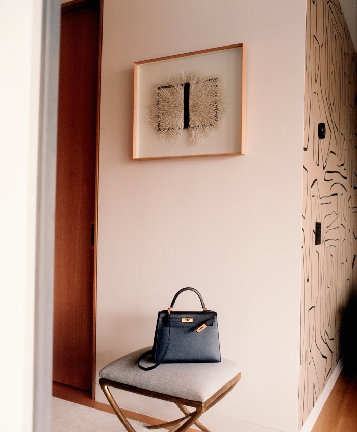 This Hermès Kelly was a gift from her husband. Above it hangs a vintage-book sculpture by Barbara Wildenboer