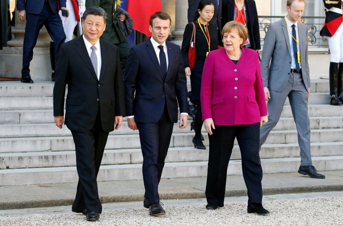 French President Emmanuel Macron (C) with Chinese counterpart Xi Jinping and Germany’s Angela Merkel after their meeting at the Elysee Presidential Palace in 2019