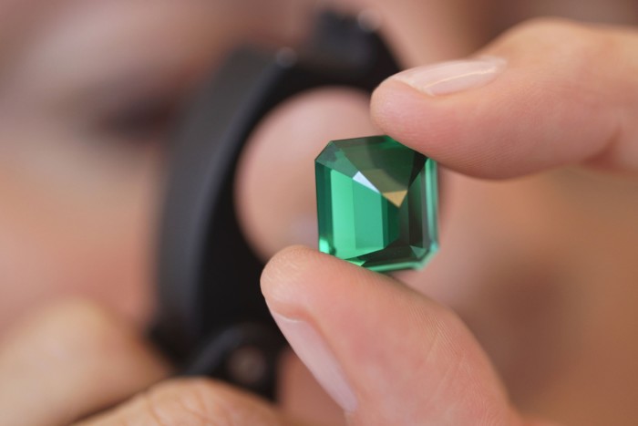 inspecting a cut-and-polished Colombian emerald
