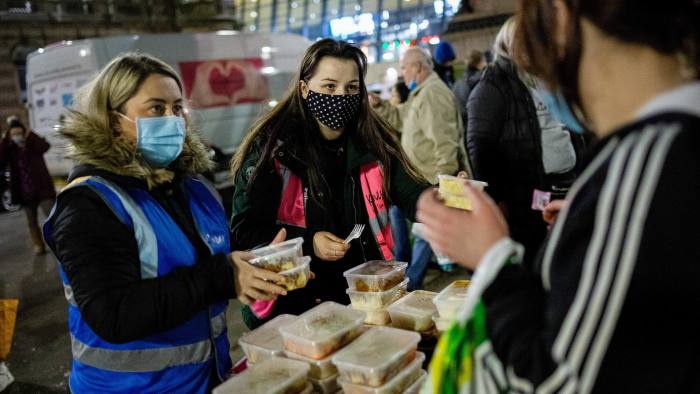 Volunteers distribute food in Glasgow city centre. On present trends, the average Slovenian household will be better off than its British counterpart by 2024