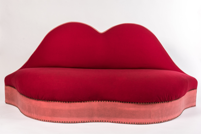 A red sofa shaped like a pair of lips - with the seat as the lower lip, and the backrest as the upper lip
