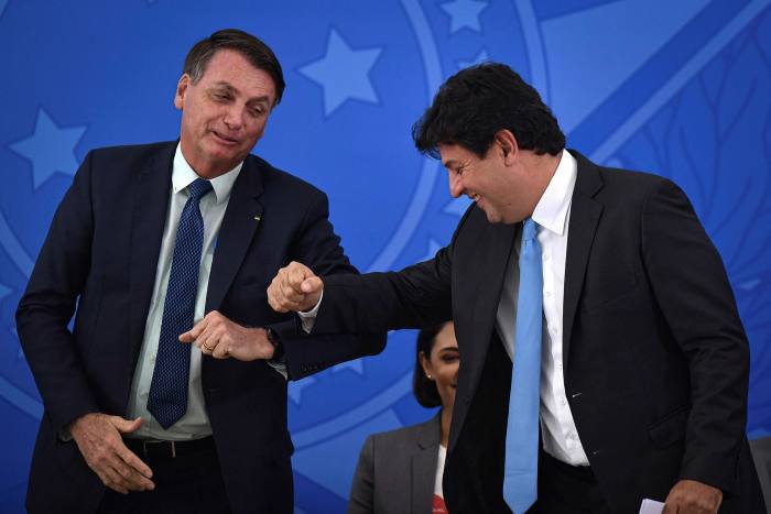 President Jair Bolsonaro, left, with outgoing health minister Luiz Henrique Mandetta. The Brazilian leader has played down the risks of the virus