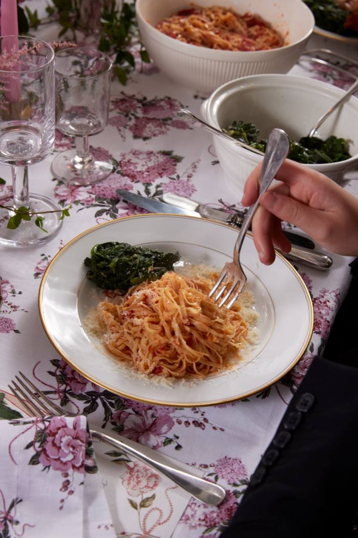 Spaghetti tossed in tomato sauce served with sautéed spinach