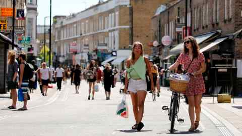 People get out in the sunshine in broadway market, Hackney, north east London on May 20, 2020