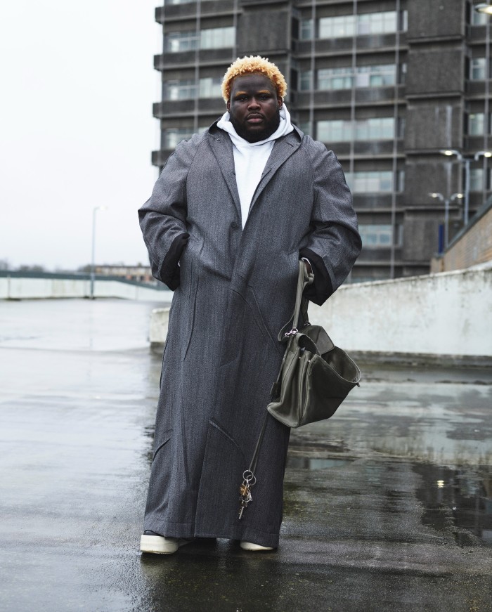 Specialist banker and model Ezekiel Kingston-Inyang, 27, wears Balenciaga wool coat, £2,982, and leather Rodeo bag with charms, £8,095. Solid Homme cotton hoodie, £260. Rick Owens leather shoes, £425. All jewellery, Ezekiel’s own