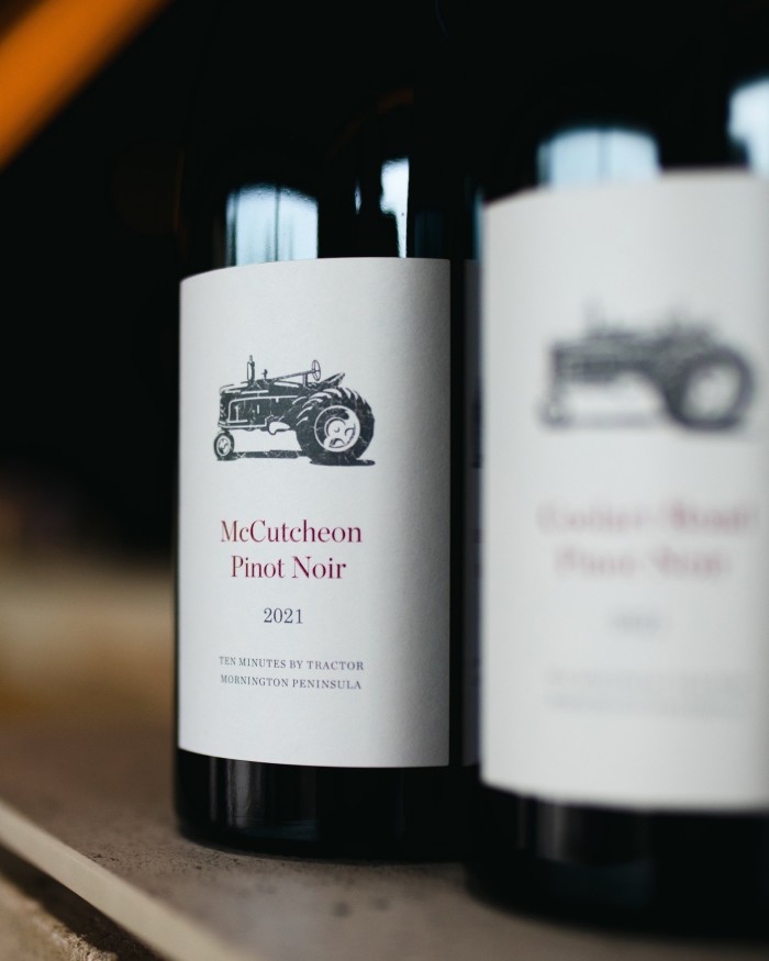 Two bottles – one of them blurred – of a Ten Minutes by Tractor Pinot Noir 