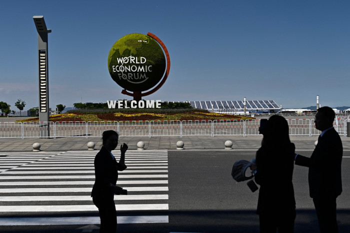 People walk past the site of the World Economic Forum’s ‘Annual Meeting of the New Champions’ in Dalian, China, on Tuesday