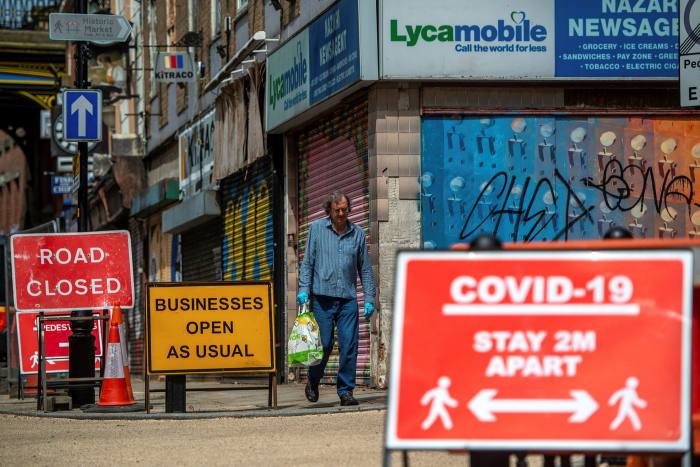 A pedestrian walks past shut shops in Stockport last month