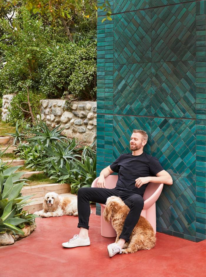 Richard Christiansen at his Flamingo Estate on a Faye Toogood seat, with cocker spaniels Daylesford and Freeway