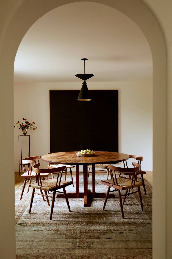 A George Nakashima dining table and chairs on an antique Malayer rug