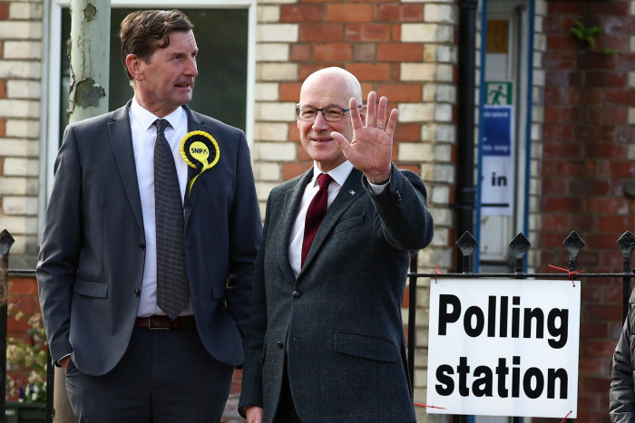 First minister of Scotland, the SNP’s John Swinney, right, arrives to vote at a polling station in Blairgowrie, Perthshire 