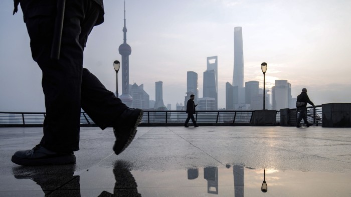 A man walks in front of the Shanghai skyline