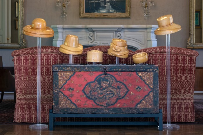 Her collection of 18th-century hats displayed on a Vietnamese trunk