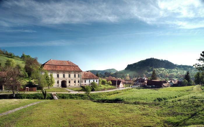 A view of the Bethlen Estate in Romania with rolling hills in the background