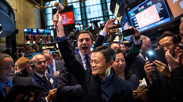 Jack Ma, his arm raised, is surrounded by a crowd at the New York stock exchange at Alibaba’s initial public offering in 2014