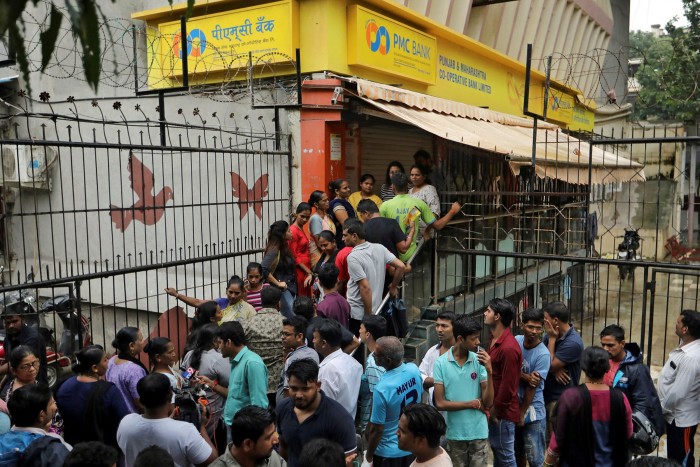 People wait outside a PMC (Punjab and Maharashtra Co-operative) Bank branch to withdraw their money in Mumbai