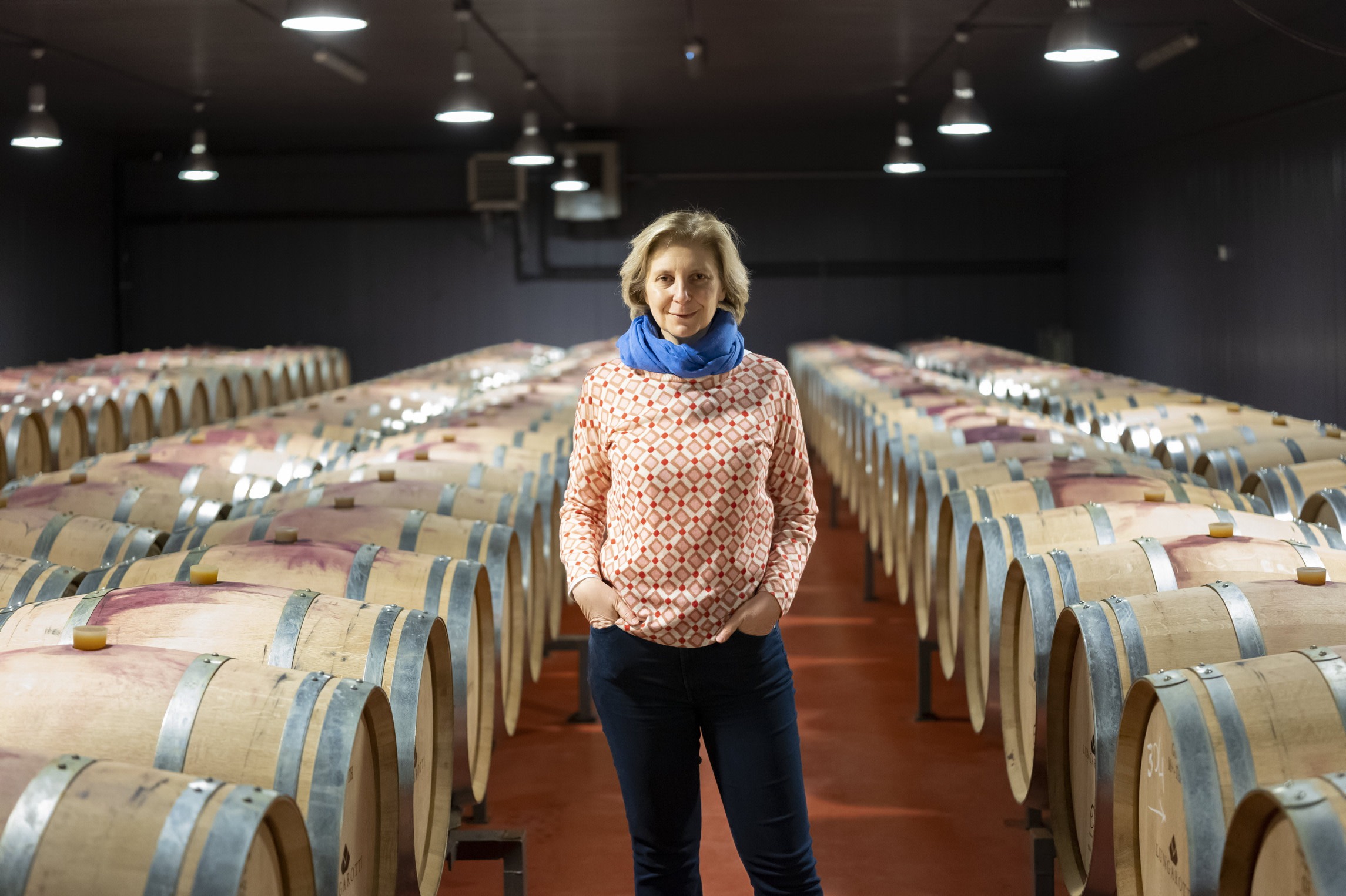 woman surrounded by wine barrels