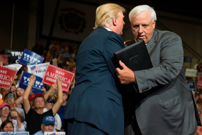The then US president Donald Trump, left, shakes hands with West Virginia governor Jim Justice in 2017