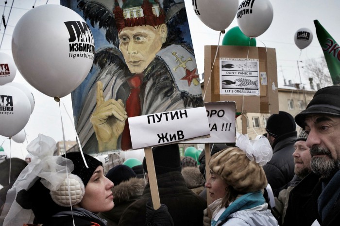 A crowd of demonstrators hold aloft anti-Putin banners