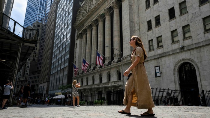 People walk near the New York Stock Exchange on Wall Street