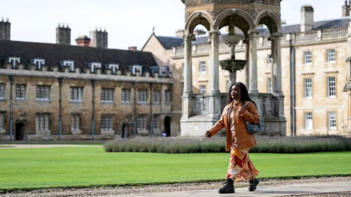 A law student at Cambridge university walks across the Great Court at Trinity College