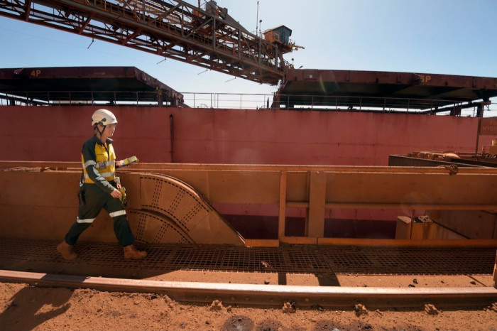An iron ore bulk carrier is moored beside a jetty at a Rio Tinto facility in Dampier, Western Australia